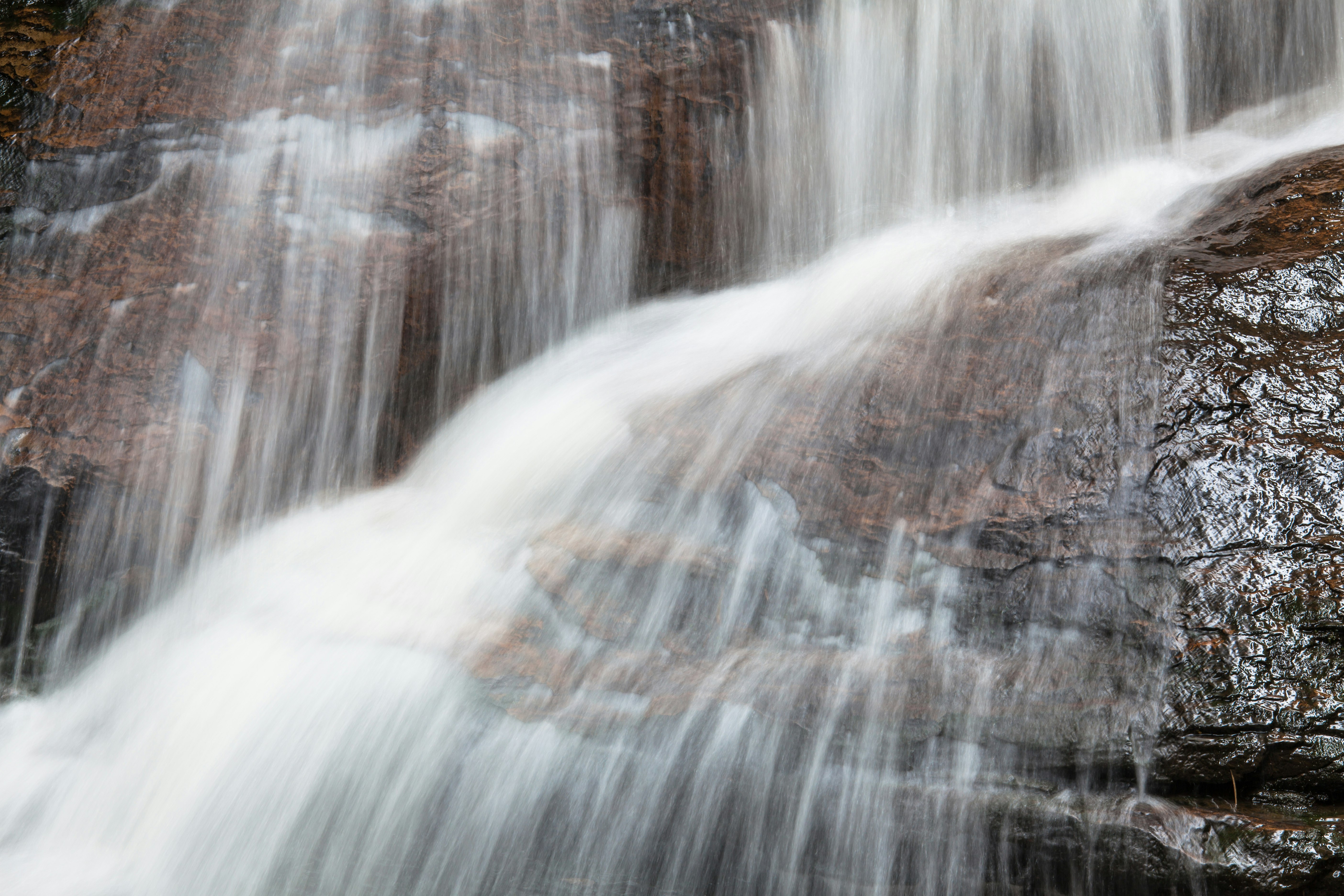 water falls on brown rock formation